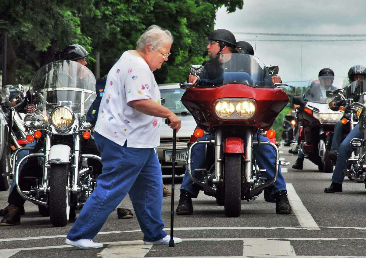 62-year-old Betsy McDermott, of Roanoke, VA, crosses Canada Street in front of a line of motorcycles as the annual Americade brings thousands of motorcyclists into Lake george Village Thursday June 5, 2008. An avid motorcyclist herself, McDermott arrived on the back of her husband's Honda Goldwing and describes Americade as the 