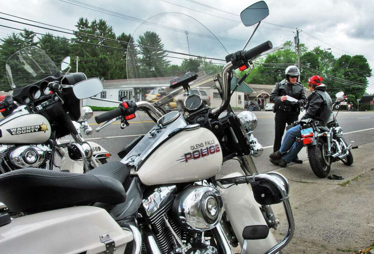 Nick Ivanoff, at right, of Seymour,Conn., receives a ticket for loud exhaust pipes on his Harley Davidson Sportster from Warren Co. Sheriff's deputy Pete DiFiore on Canada Street as the annual Americade brings thousands of motorcyclists into Lake George Village Thursday June 5, 2008. DiFiore was also riding a Harley Davidson.