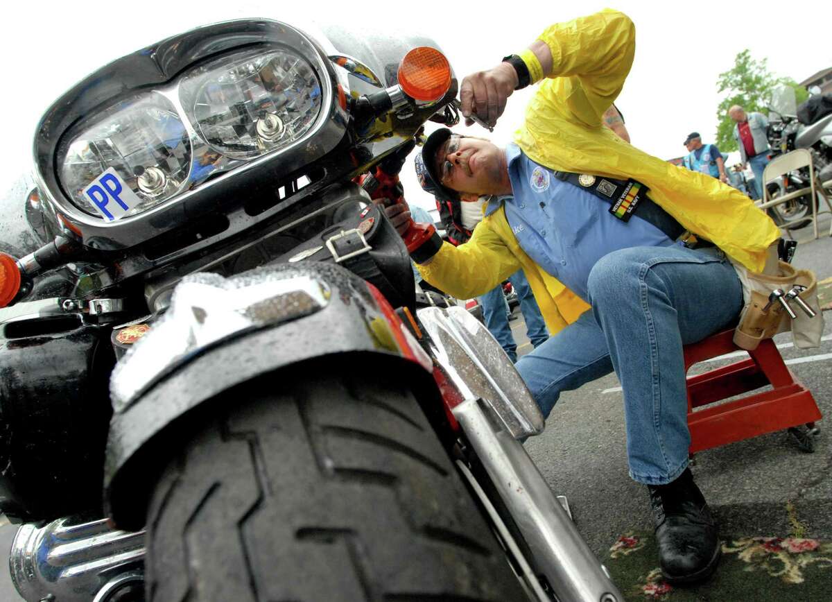 Mike Riley of Baker Built Air Wings installs air wings on a Honda Valkyrie during Americade on Wednesday, June 7, 2006, in Lake George, N.Y.