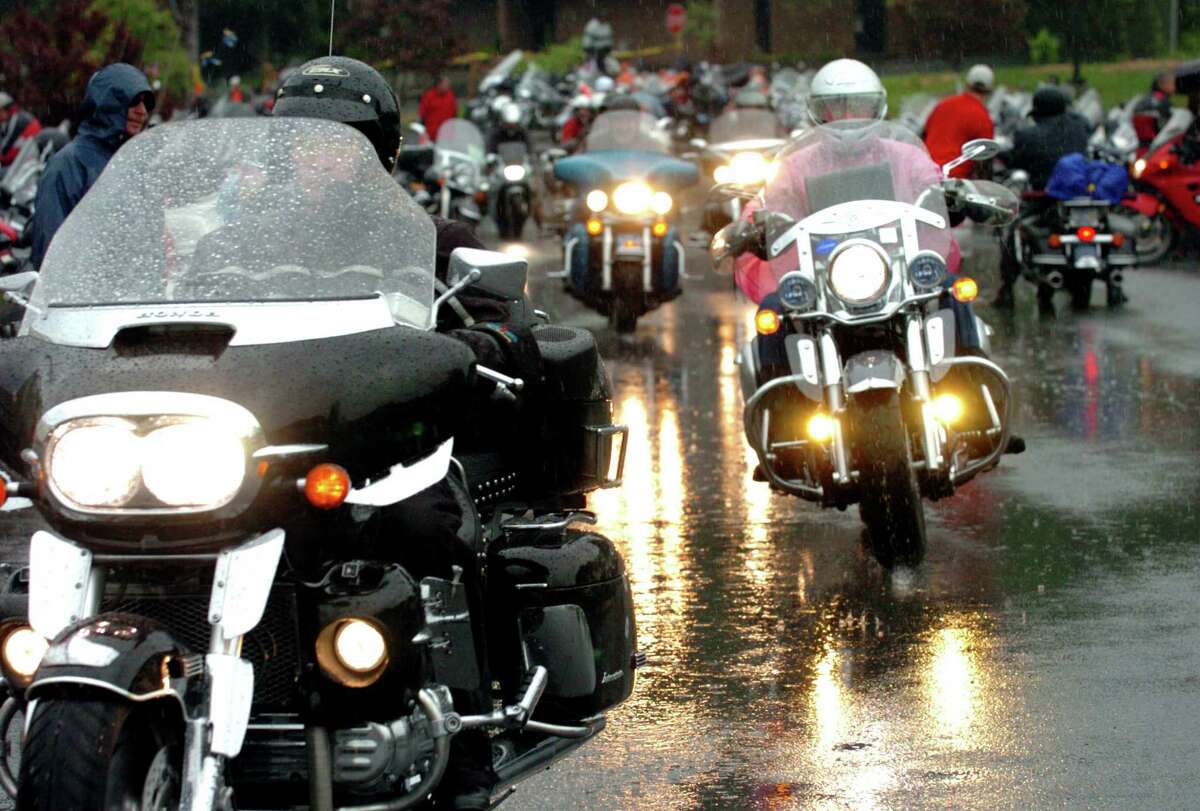 Motorcyclists drive in the pouring rain as they depart from the Lake George Forum during Americade on Wednesday, June 7, 2006, in Lake George, N.Y. 