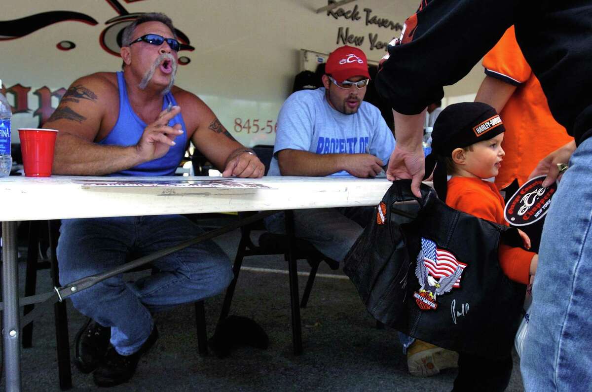 Ethan Beebe of North Granville, 3, gets an autograph from Paul Teutul Sr., left, and his son Paul, Jr. right, of the 