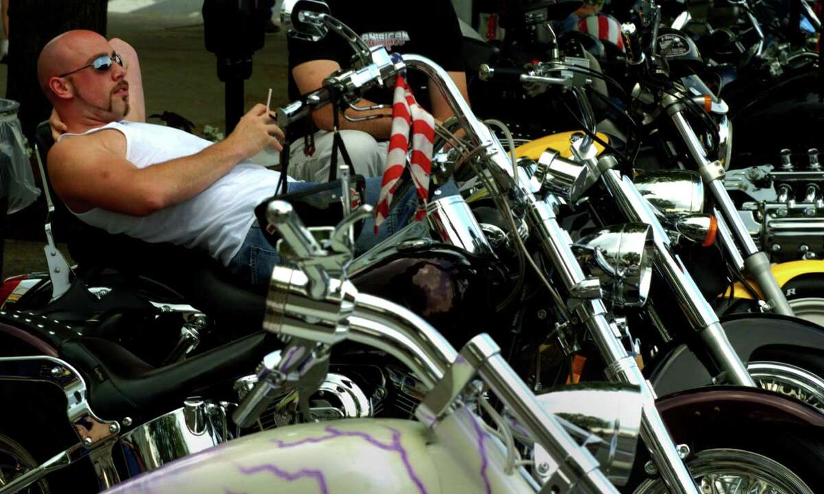 Paul Epting of Colonie reclines on his 2001 Honda Shadow parked along Canada Street as he watches other attendees of Americade in Lake George, NY Monday June 7, 2004.