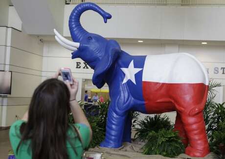 Sarah Mercer, of San Antonio, makes a photo of a Texas flag elephant statue during the set up before the start of the Texas Republican Convention Wednesday, June 6, 2012, in Fort Worth, Texas.  The Texas GOP convention starts tomorrow and runs through Saturday. (LM Otero / Associated Press)