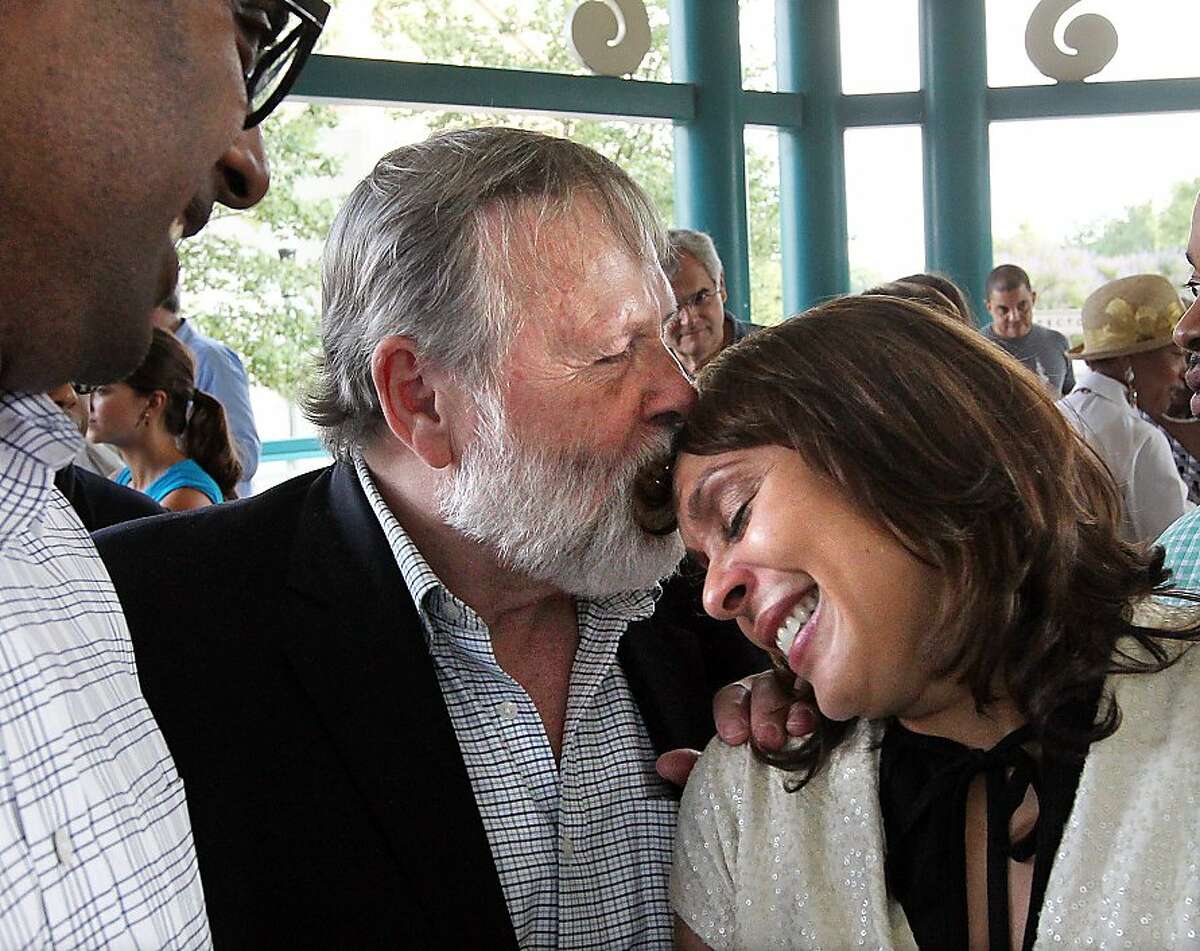 U.S. Poet Laureate Natasha Trethewey is kissed by her father Eric Trethewey with her husband Brett Gadsden looking on after her recognition during a city wide celebration in Decatur, Ga., on Thursday, June 7, 2012. The Library of Congress named Trethewey on Thursday to be its 19th U.S. poet laureate with a mission to share the art of poetry with a wider audience. The 46-year-old English and creative writing professor at Atlanta's Emory University distinguished herself early, winning the Pulitzer Prize in 2007. (AP Photo/Atlanta Journal-Constitution, Curtis Compton)