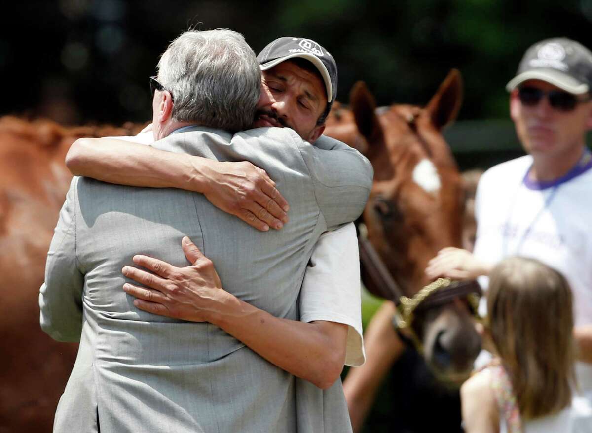 Owner J. Paul Reddam, left, is hugged by groom Incencio Diaz as Kentucky Derby and Preakness winner I'll Have Another is petted in the background after a news conference at Belmont Park in Elmont, N.Y., on Friday, June 8, 2012. I'll Have Another's bid for a Triple Crown ended with the shocking news that the colt was out of the Belmont Stakes due to a swollen left front tendon. The Belmont Stakes horse race is Saturday.