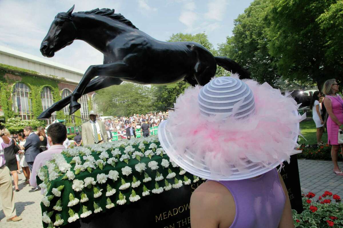 Julia Hanson, 8, of Chicago, looks at a statue of 1973 Triple Crown winner Secretariat prior to the Belmont Stakes horse race, Saturday, June 9, 2012, at Belmont Park in Elmont, N.Y. I'll Have Another, who won both the Kentucky Derby and the Preakness, was scratched Friday from the Belmont Stakes, ending his shot at the Triple Crown.