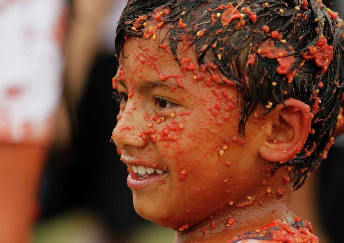 A child covered with smashed tomato participates in the sixth annual tomato fight festival called "tomatina" in Sutamarchan, some 71 miles northeast of Bogota, Colombia, Sunday, June 10, 2012.
