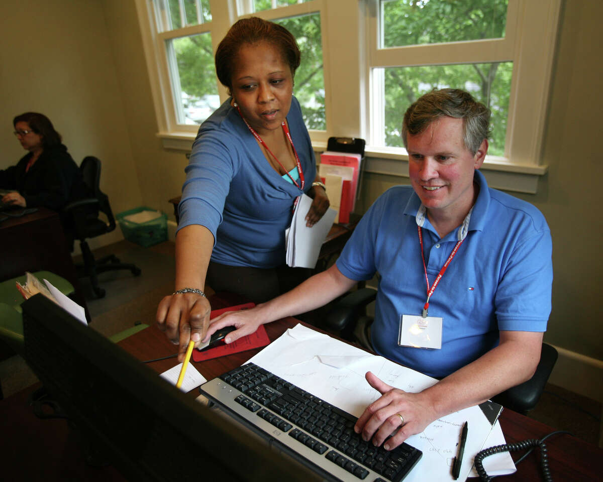 Social worker Natasha Ducasse, left of Greenwich, helps volunteer Ed Kearns, of New Canaan, get up to speed at Person-to-Person in Darien on Tuesday, June 5, 2012. Person-to-Person utilises the website, volunteersquare.org, to find volunteers.