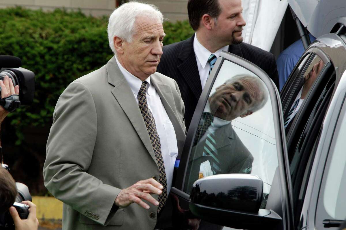 Former Penn State assistant football coach Jerry Sandusky, center, leaves the Centre County Courthouse after the first day of his trial with his attorney Karl Rominger, right rear, in Bellefonte, Pa., Monday, June 11, 2012. Sandusky is accused of 52 counts of child sexual abuse involving 10 boys over a period of 15 years.