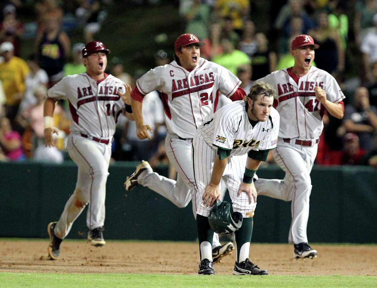 Arkansas players John Clay Reeves, left, DJ Baxendale (24), and Tyler Wright, right run past Baylor's Max Muncy (9) after defeating Baylor in the 10th inning of an NCAA college baseball tournament super regional game, Monday, June 11, 2012, in Waco, Texas. Arkansas advances to the College World Series. (AP Photo/Waco Tribune Herald, Jerry Larson)