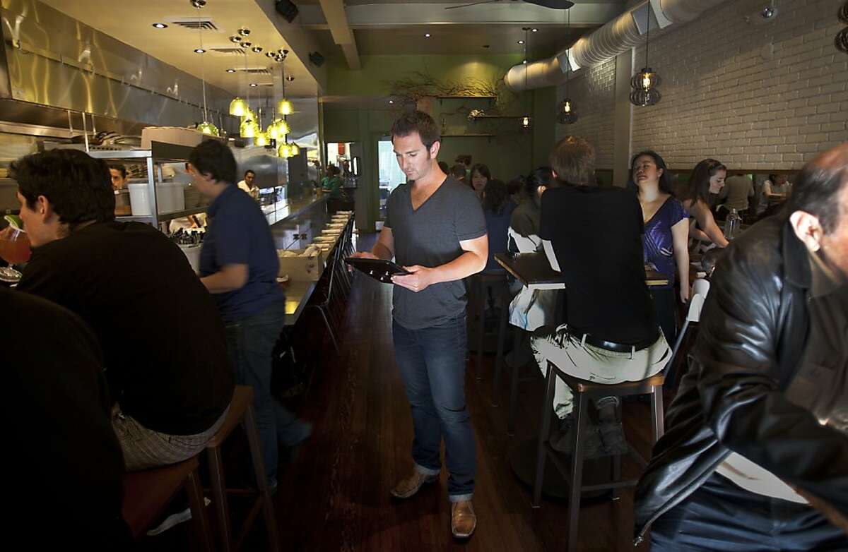 Cody Rose of Noshlist uses the free app in the midst of the busy Nopaloto restaurant in San Francisco on Friday June 8, 2012. Noshlist is a free restaurant app hat texts diners to tell them their table is ready. It ha close to 1,000 clients including San Francisco's Nopalito.