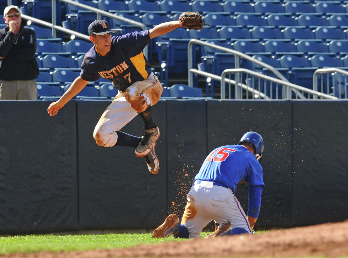 Weston's #7 Charles Ameer leaps over Plainville's #15 Christopher Kuzia in a play at third, during boys baseball Class M Semifinals action at the Ballpark at Harbor Yard in downtown Bridgeport, Conn. on Tuesday June 05, 2012.