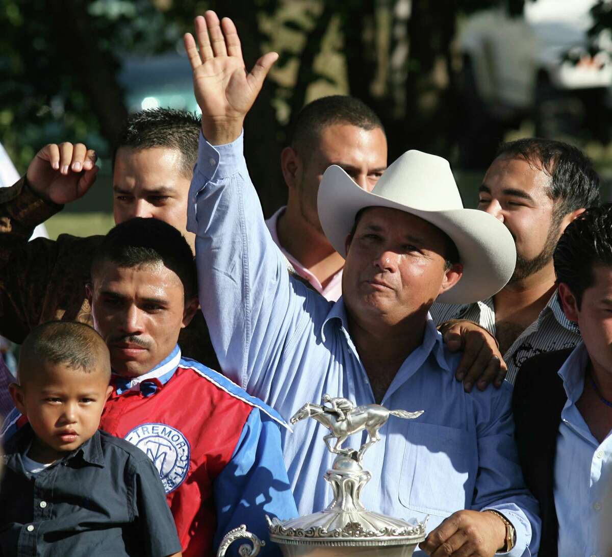In this photo taken Sept. 6, 2010, owner Jose Trevino Morales, center, acknowledges the crowd as he stood with the trophy after Mr. Piloto won the All American Futurity horse race at Ruidoso Downs, N.M. Federal agents raided a sprawling ranch in Oklahoma and the prominent quarter horse track in New Mexico on Tuesday, June 12, 2012, alleging the brother of a high-ranking official in a Mexican drug cartel used a horse-breeding operation to launder money. Seven of the 14 people indicted were arrested, including Jose Trevino Morales. (AP Photo/The El Paso Times, Rudy Gutierrez) EL DIARIO OUT; JUAREZ MEXICO OUT;