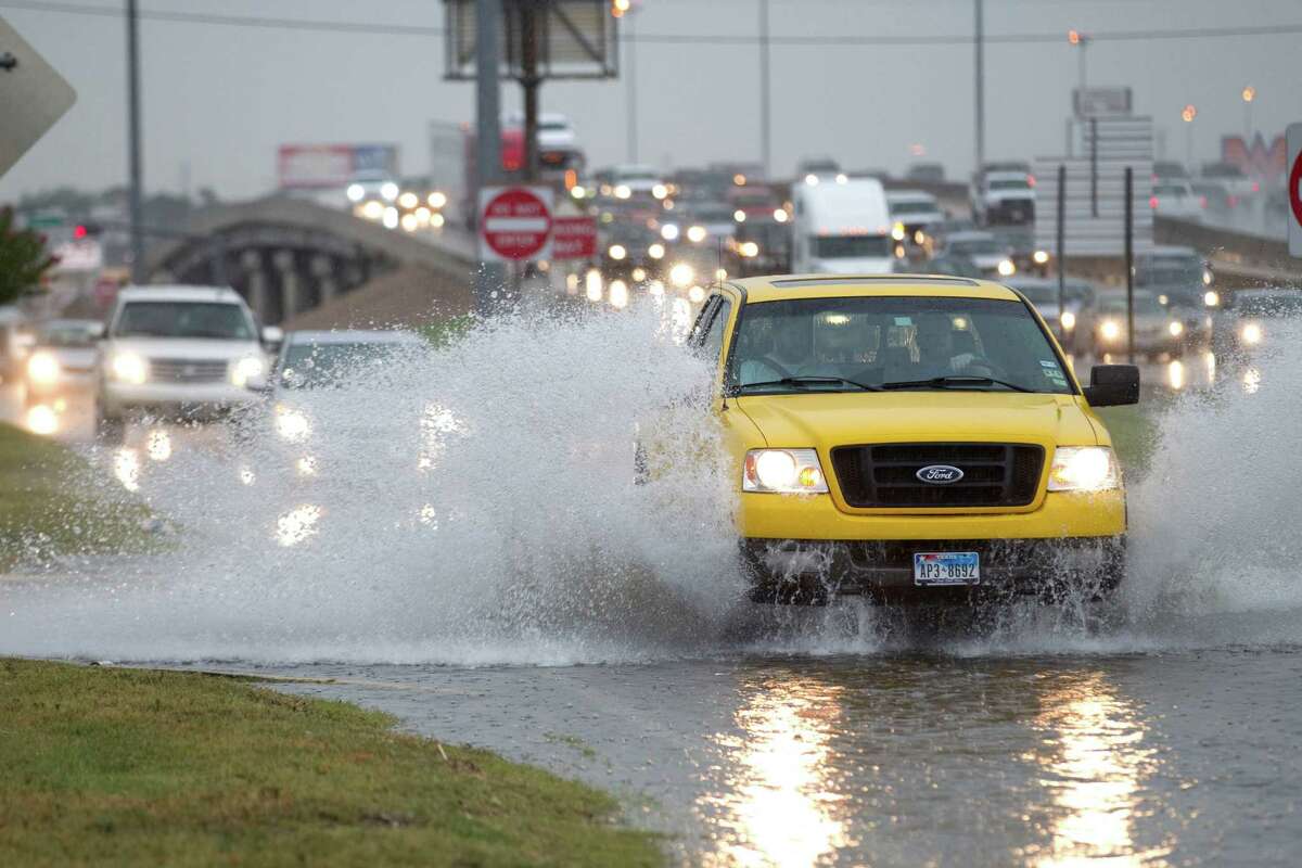 A truck splashes through high water during a heavy rain storm near I-45 at Airline Tuesday, June 12, 2012, in Houston.