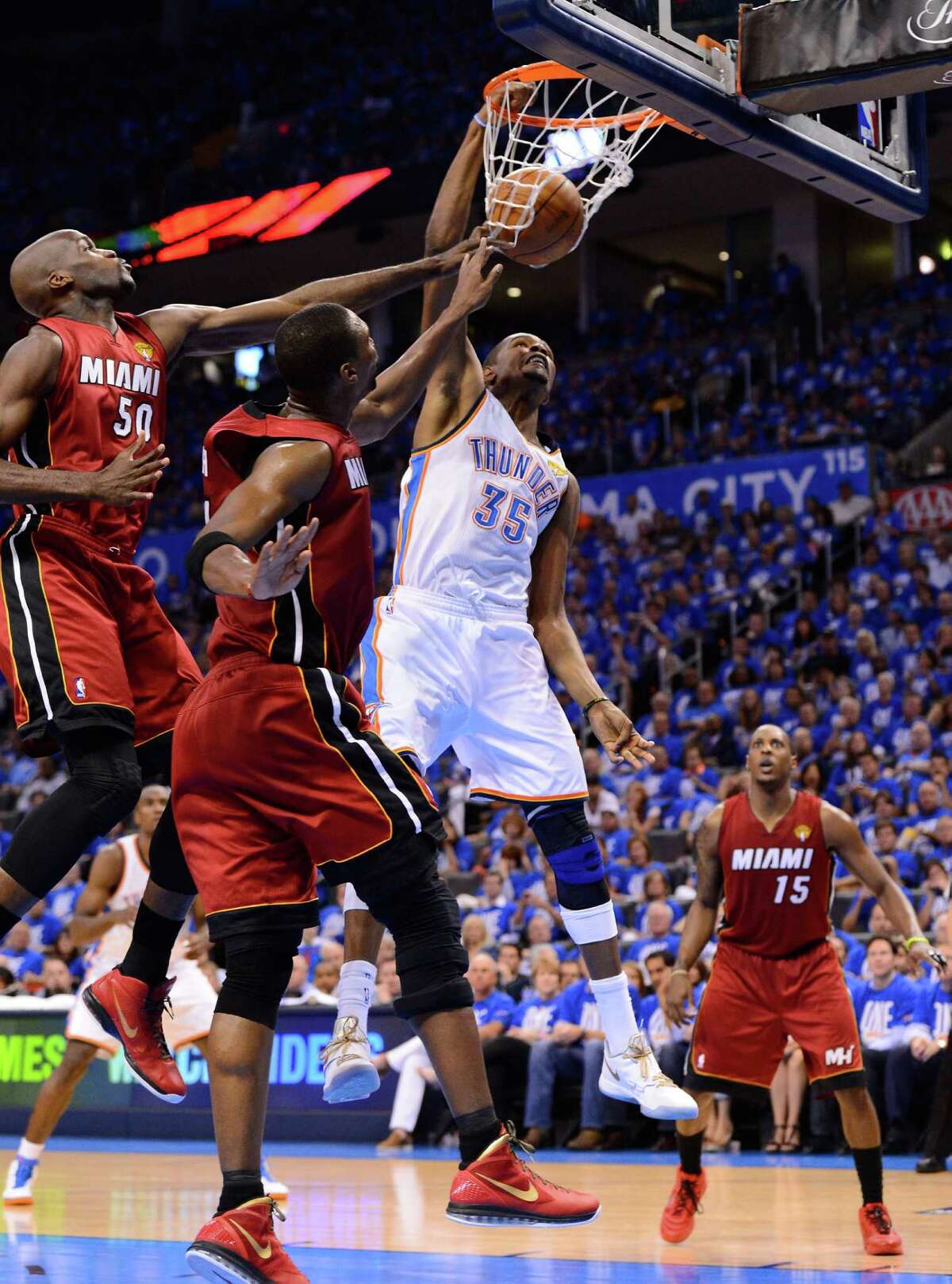 OKLAHOMA CITY, OK - JUNE 12: Kevin Durant #35 of the Oklahoma City Thunder dunks the ball over Joel Anthony #50 and Chris Bosh #1 of the Miami Heat in the second quarter in Game One of the 2012 NBA Finals at Chesapeake Energy Arena on June 12, 2012 in Oklahoma City, Oklahoma. NOTE TO USER: User expressly acknowledges and agrees that, by downloading and or using this photograph, User is consenting to the terms and conditions of the Getty Images License Agreement.