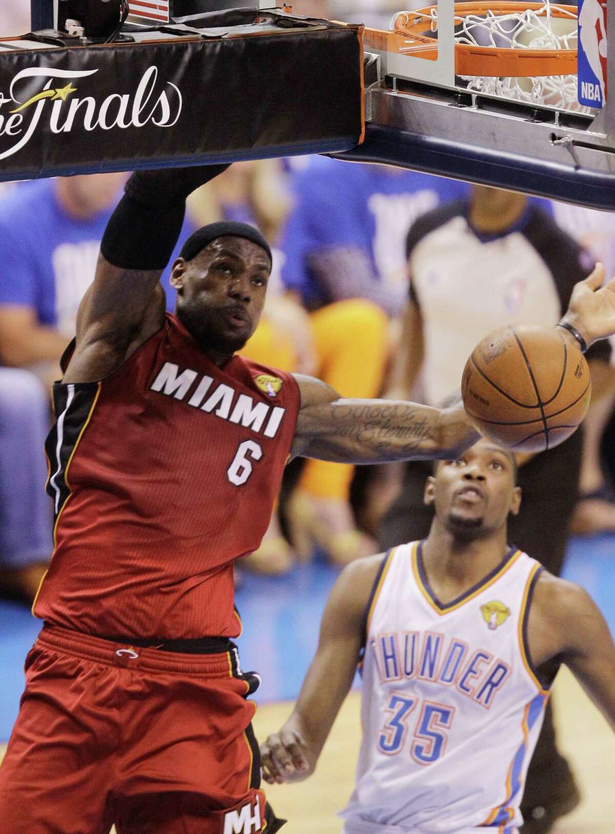 Miami Heat small forward LeBron James dunks against the Oklahoma City Thunder during the first half at Game 1 of the NBA finals basketball series, Tuesday, June 12, 2012, in Oklahoma City. At right is Thunder's Kevin Durant (35). (AP Photo/Sue Ogrocki)