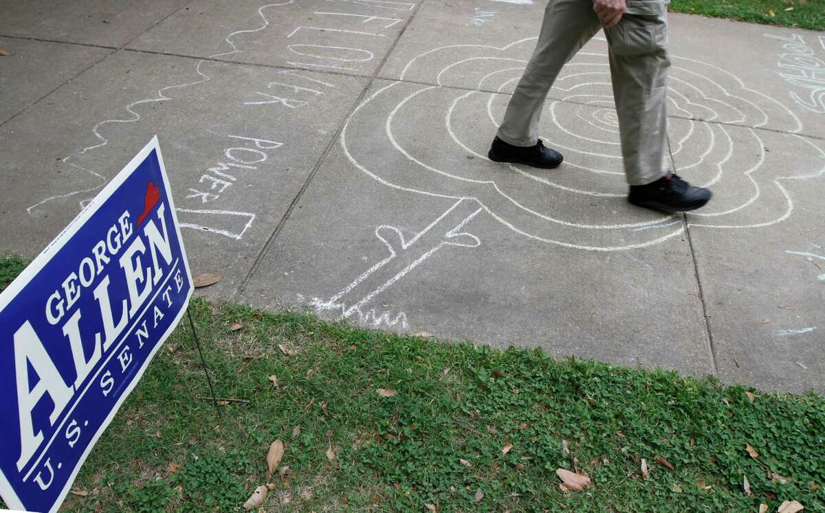 A voter walks past a campaign sign and over some drawings as he prepares to vote in the Republican primary at a school in Richmond, Va., Tuesday, June 12, 2012. (AP Photo/Steve Helber)