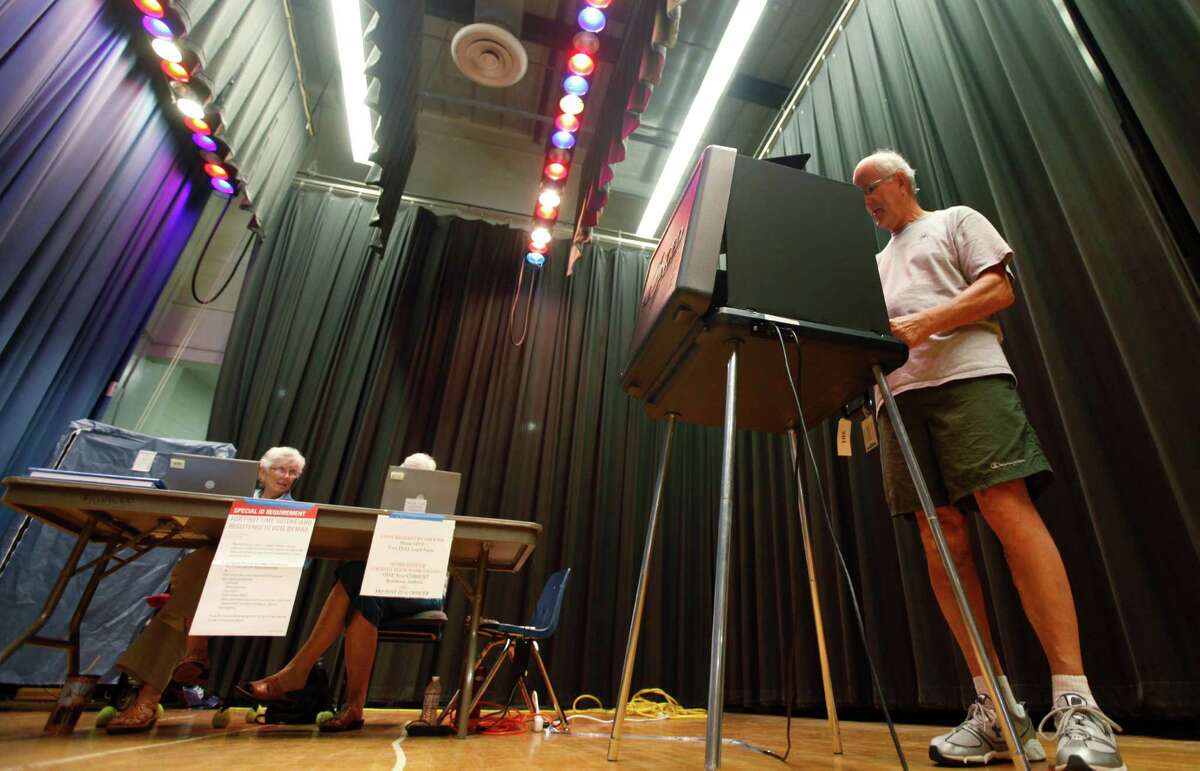 Jim Teachey votes in the Republican primary at a school precinct in Richmond, Va., Tuesday, June 12, 2012. Turnout was low in the precinct that is set up in the auditorium stage of a local school. (AP Photo/Steve Helber)