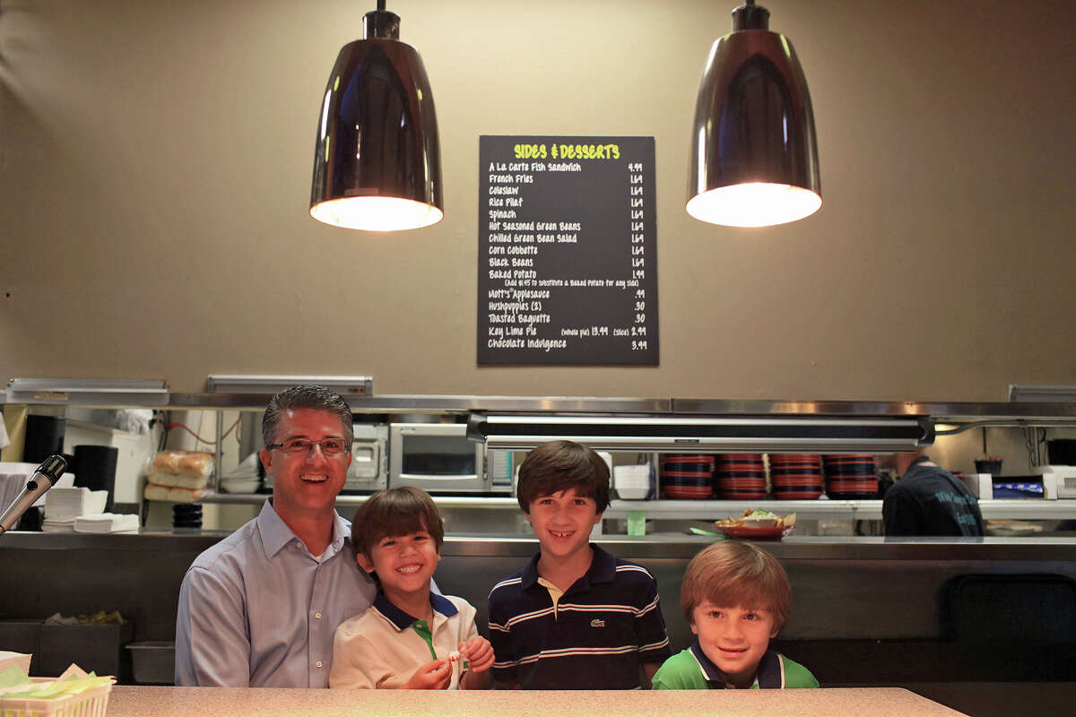 Barclay Anthony stands with his sons, Beau, 5 (from left), Luke, 10, and Wyatt, 8, at their family's restaurant, Sea Island Shrimp House.
