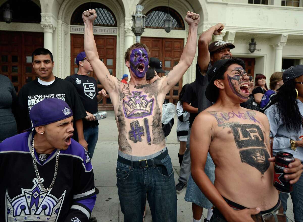 Corey Brankin (C) and Johnny Castellanos (R) from Lancaster, California, cheer before the start of the Los Angeles Kings Stanley Cup victory parade on June 14, 2012 in Los Angeles, California. The Kings are celebrating thier first NHL Championship in the team's 45-year-old franchise history.