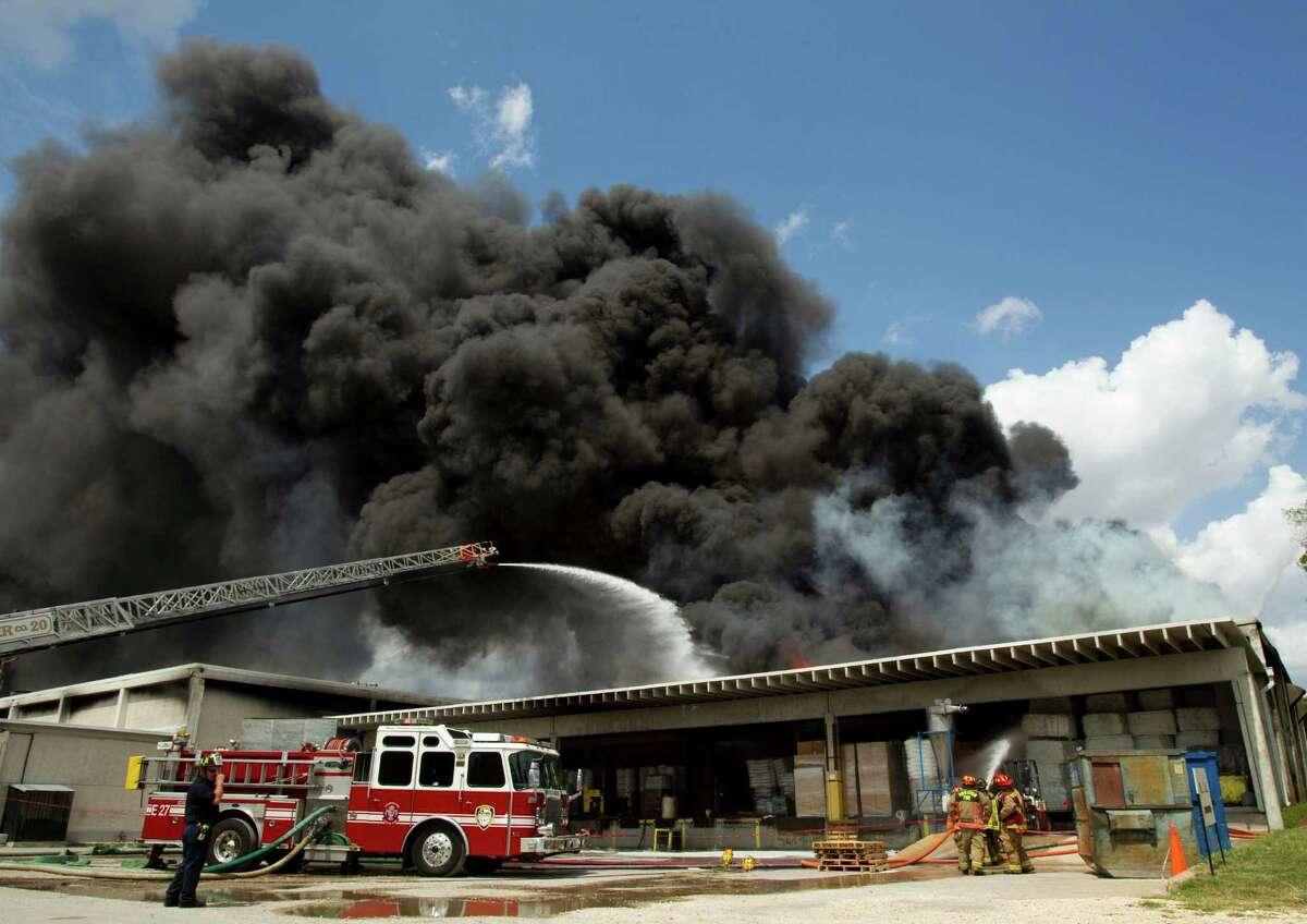 Houston firefighters battle a multiple alarm blaze at a warehouse which stores oil spill clean-up products Thursday, June 14, 2012, in Houston. One firefighter was treated at the scene for heat exhaustion.