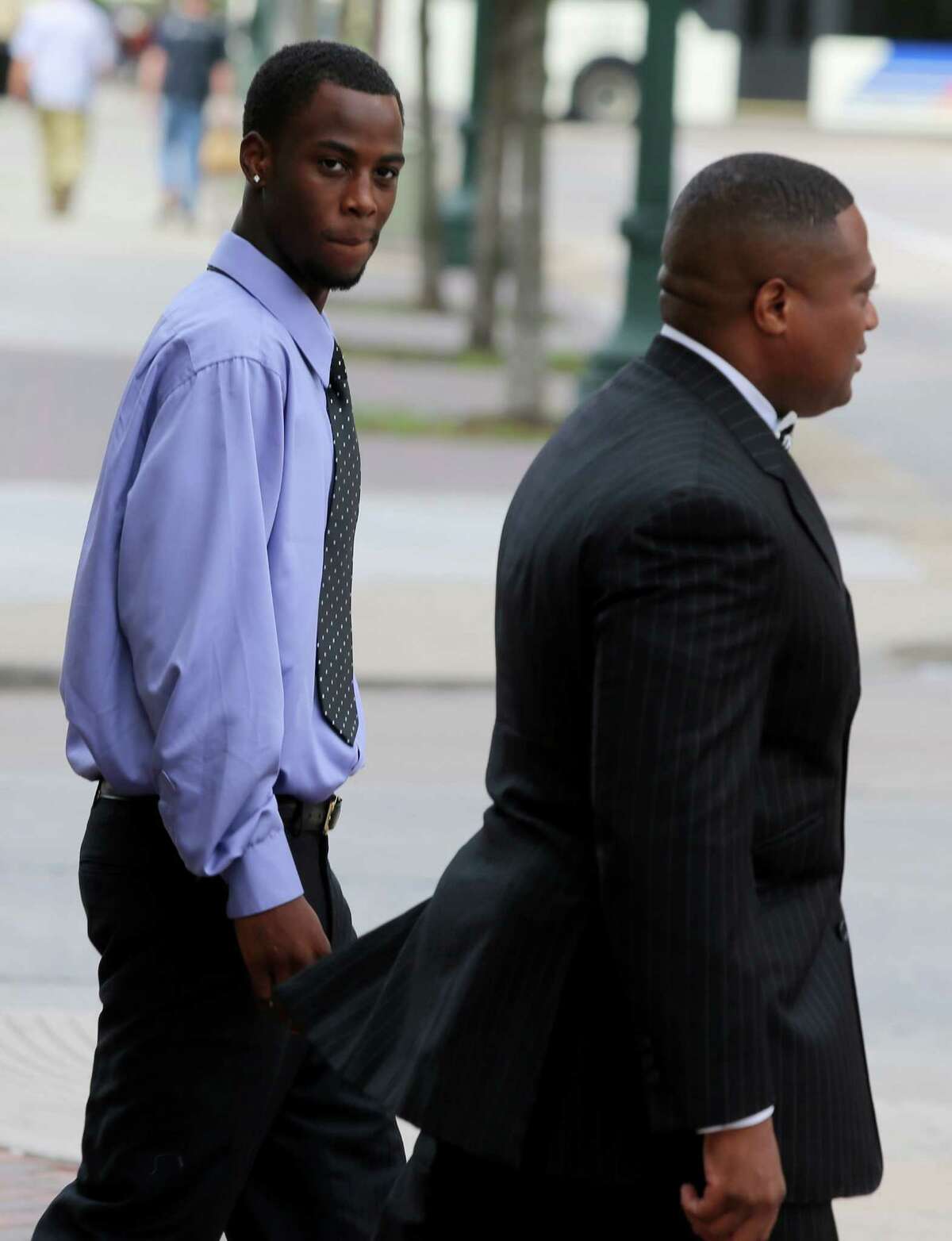 Chad Holley walks with Quanell X after leaving the 178th District Court on Friday.