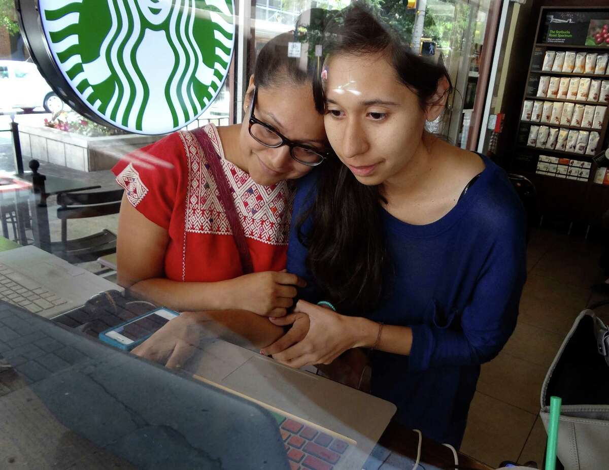 Carolina Canizales, right, and Pamela Resendiz, who are both illegal immigrants that are hoping for legal status through the DREAM Act, watch an internet broadcast of President Barack Obama announcing a stop to deportations on Friday, June 15, 2012.