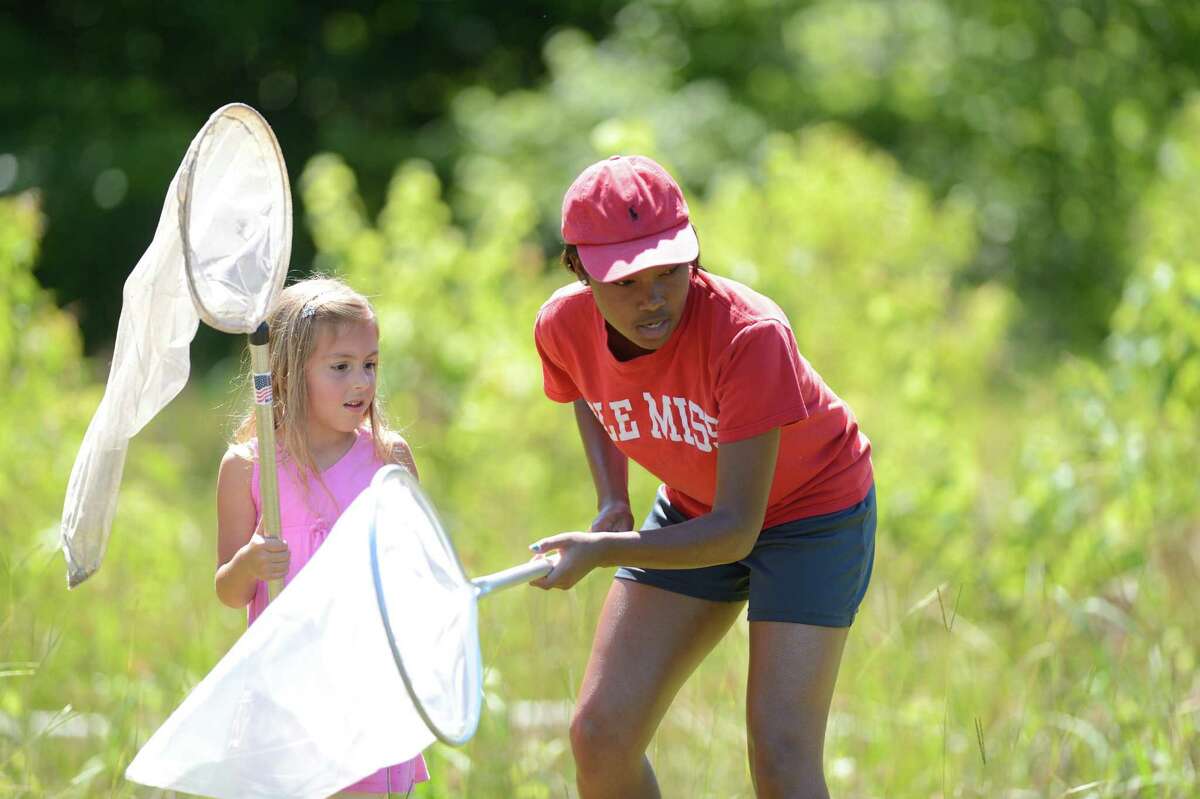 Second-grader Emily Bond, left, is assisted by camp counselor Tracie Harris in catching dragonflies for study as part of Ecology Day Camp at the University of Mississippi Biological Field Station in Abbeville, Miss.
