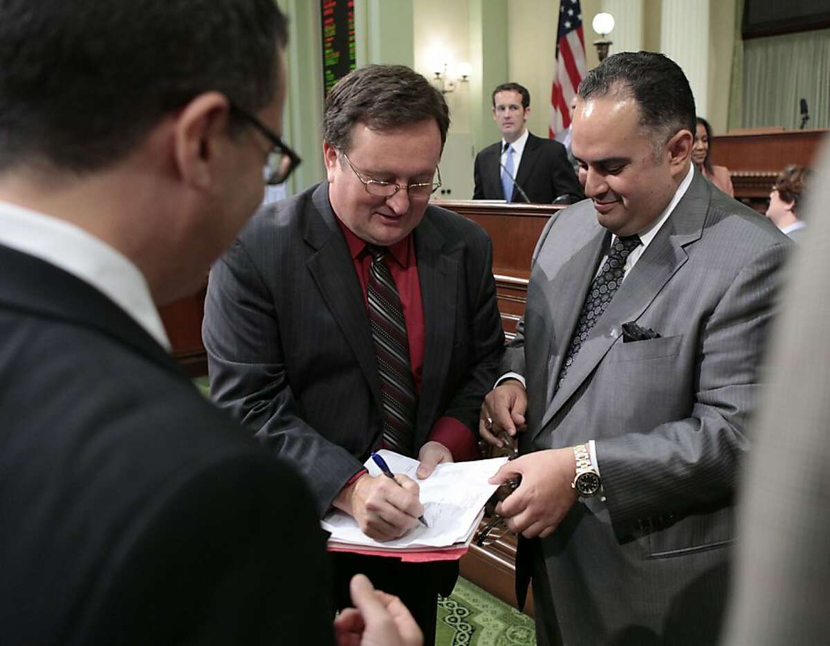 Assemblyman Kevin Jeffries, left, signs a copy of the budget vote for Assembly Speaker John Perez, right, after the Assembly passed the 2012-13 spending plan on a 50-25 at the Capitol in Sacramento in June.  The state of California faces just a $1.9 billion budget gap next year.