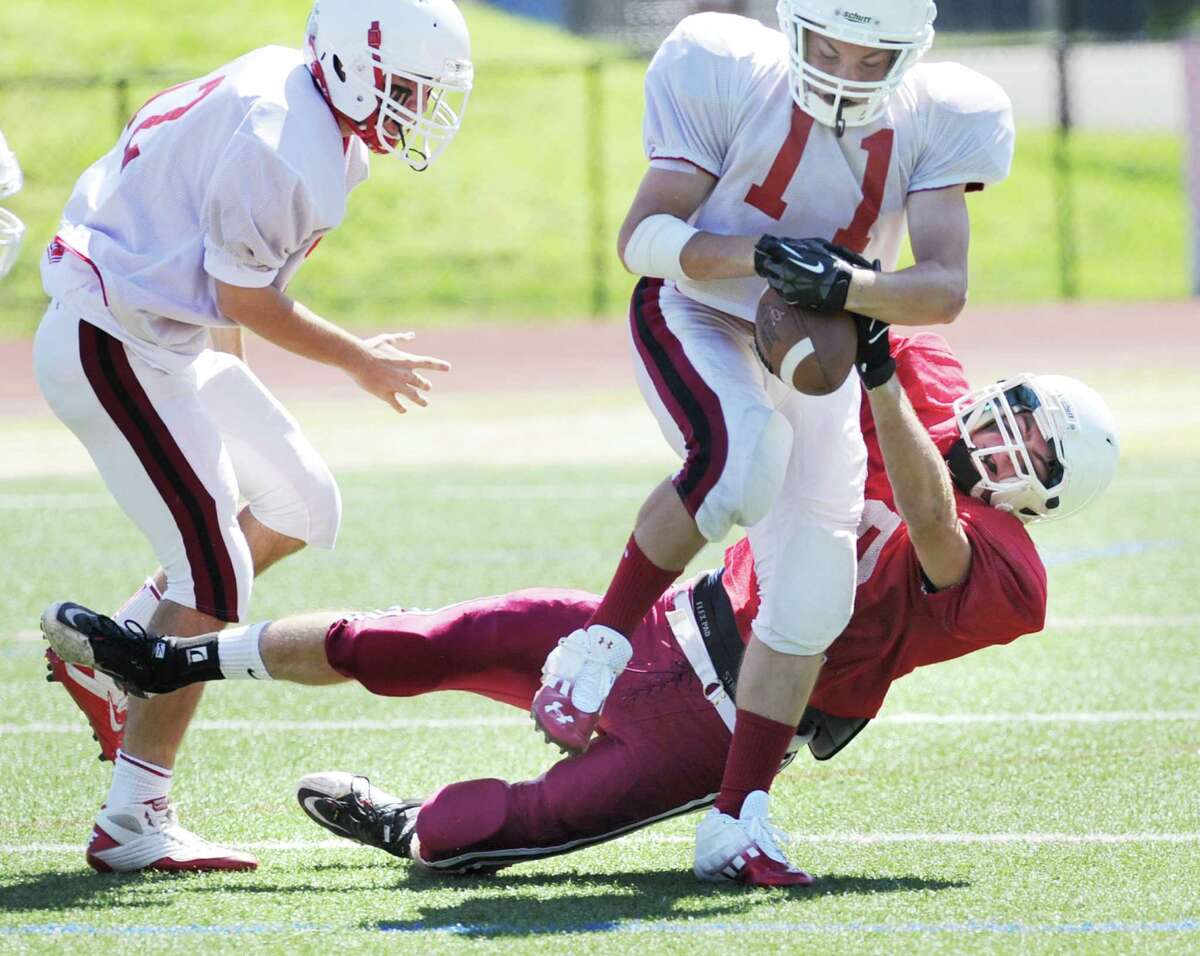 At bottom, Taylor Olmstead of the red team causes a fumble on Alex McMurray # 11 of the white team after a McMurray reception during the Greenwich High School Football annual Red & White game at Cardinal Stadium in Greenwich, Saturday, June 16, 2012.
