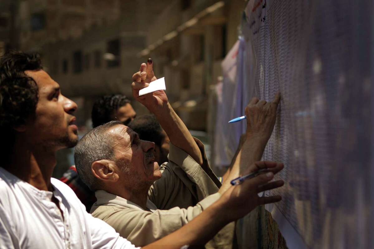 Egyptian Christian Coptic men check the voters' list outside a polling station in the Cairo Coptic neighborhood of Shubra on June 16, 2012. Egyptians were voting in a run-off presidential election pitting an Islamist against Hosni Mubarak's last premier amid political chaos highlighted by uncertainty over the future role of the army.