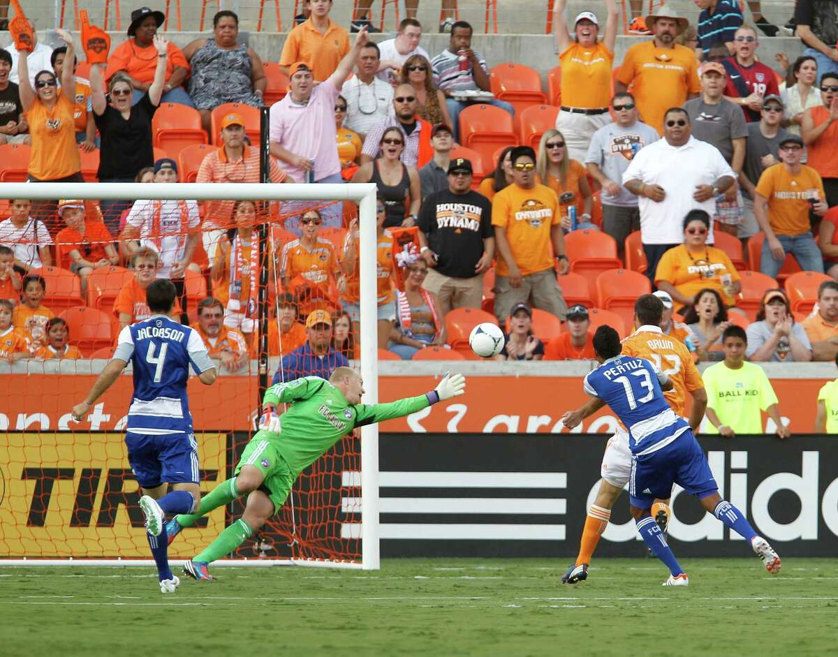 The FC Dallas goalkeeper Kevin Hartman 2nd from left, misses blocking a shot for a goal by the Houston Dynamo forward Will Bruin right, during the first half of MLS game action at BBVA Compass Stadium Saturday, June 16, 2012, in Houston.