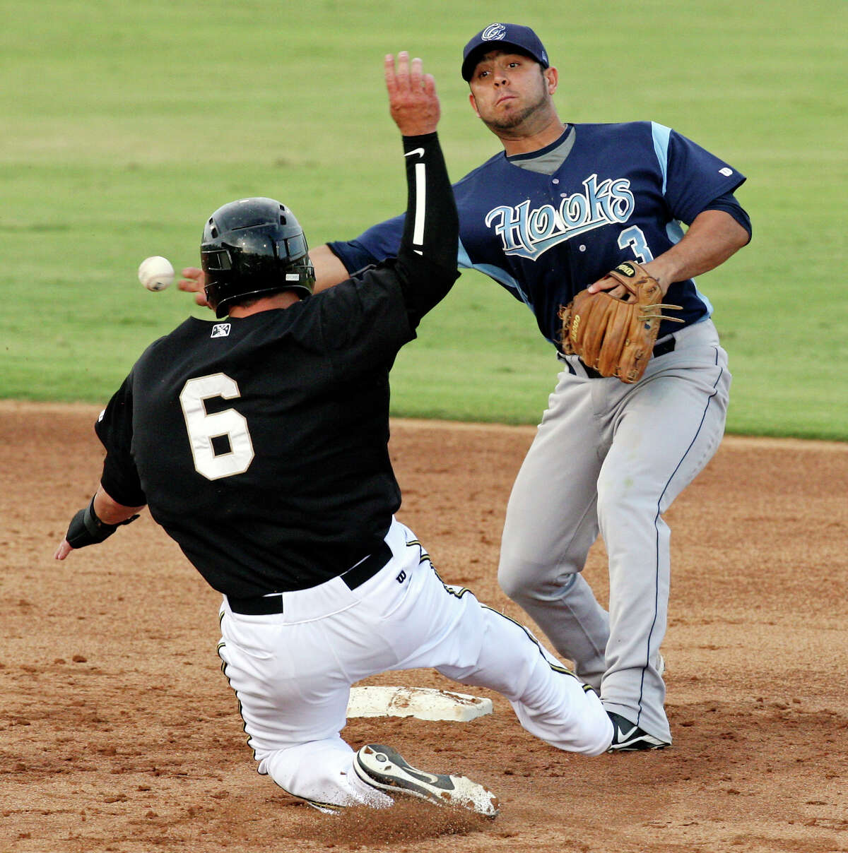 Hooks' Jose Martinez throws around Missions' Jake Blackwood after the out during the second inning Monday, June 18, 2012 at Nelson Wolff Municipal Stadium.