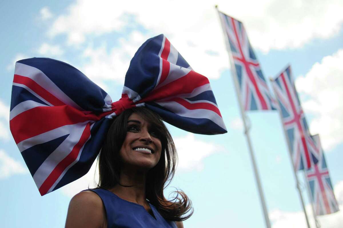 A race-goer wearing a flamboyant hat poses for the media at the annual Royal Ascot horse racing event near Windsor, Berkshire on June 19, 2012. The five-day meeting is one of the highlights of global horse racing and the pinnacle of the English social calendar. AFP PHOTO / CARL COURTCARL COURT/AFP/GettyImages