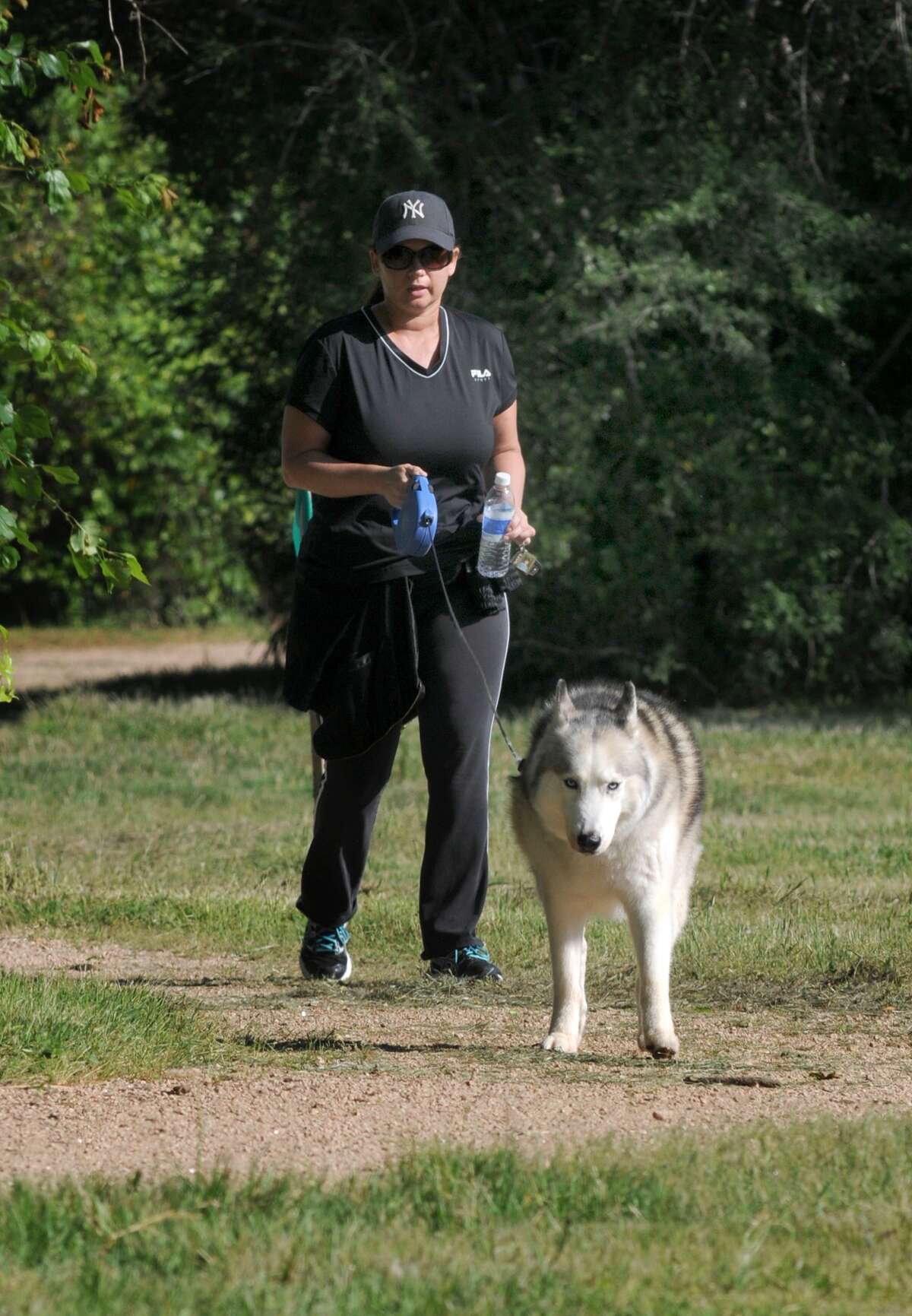 A woman exercises her dog on the Cypress Creek Nature Trail.