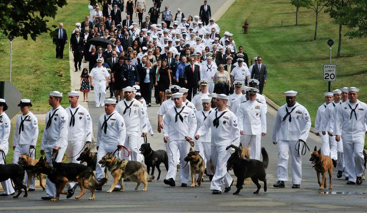 US navy military working dog handlers attend the burial service of U.S. Navy Petty Officer 2nd Class Sean E. Brazas of Greensboro, North Carolina, June 19, 2012 at Arlington National Cemetery in Arlington, Virginia.