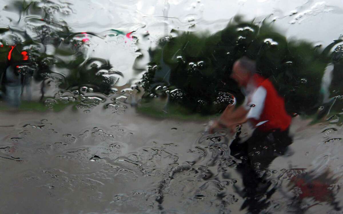 A cyclist crosses T.C. Jester while riding along Ella as rain fell Tuesday, June 19, 2012, in Houston.