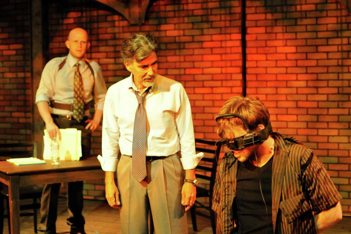 Tyler Keyes (from left) and Roger Alvarez play cops investigating a writer (Michael Burger) in the Woodlawn Black Box Theatre’s staging of “The Pillowman.”
