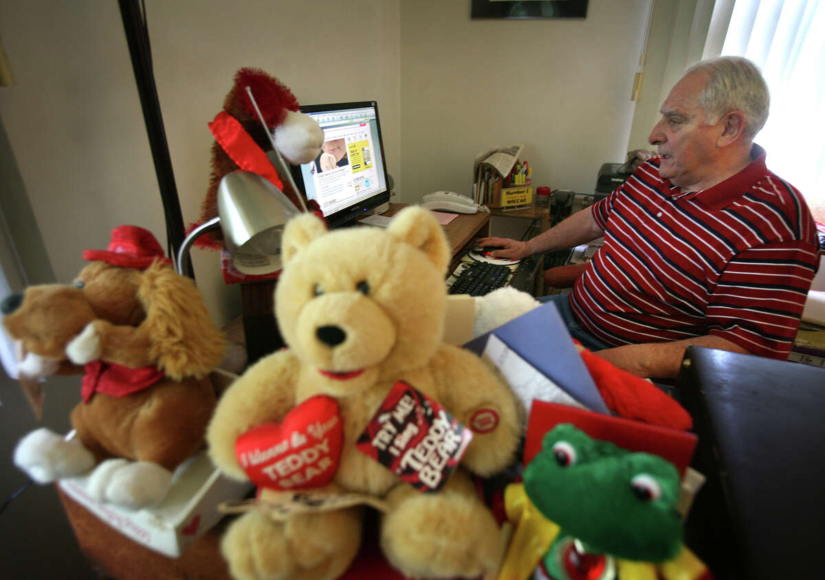 With gifts from listeners piled nearby, Al Warren does online research for his WICC morning radio show at his home in Milford on Tuesday, June 19, 2012. Warren is retiring from the station after 44 years.