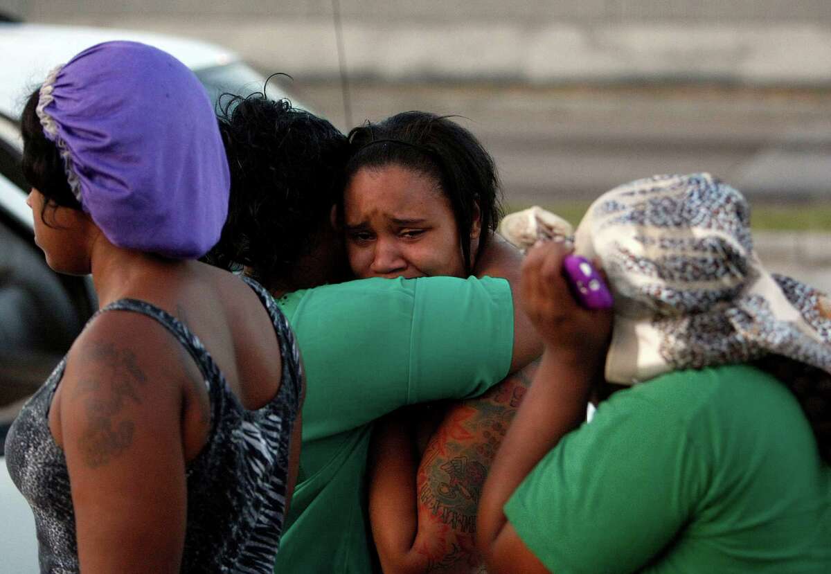 A woman is consoled as police investigate a crime scene outside a Houston night club, Wednesday, June 20, 2012. Three people were killed and two wounded from gunfire outside the night club. The shooting occurred in a strip mall parking lot outside the Score's Cabaret strip club and an adjacent night club. The shots rang out right around 3 a.m., just as some 300 people were exiting the night club after a rap concert.