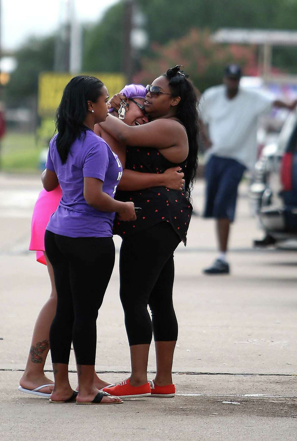 Unidentified family and friends react during a vigil at the scene of a strip club where three people were shot to death and two were injured including local rapper Trae Tha Truth, early Wednesday morning, Wednesday, June 20, 2012, in Houston.