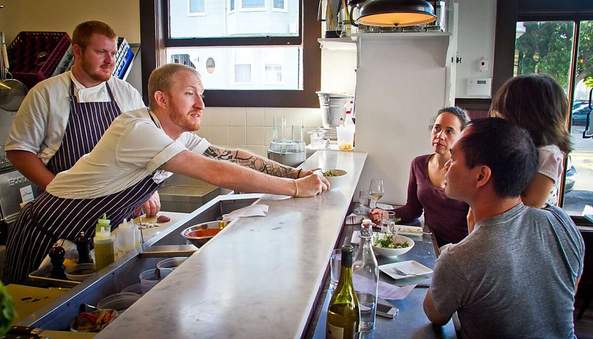 Timmy Malloy and Ian Schoening, (left), serves a dish to a family sitting at the counter at Local's Corner restaurant in San Francisco, Calif., on Friday, June 15th, 2012.