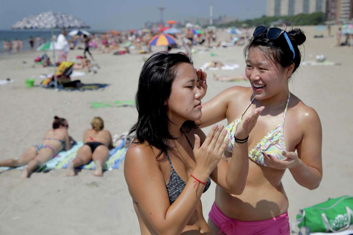 Kristi Moy, right, helps Kinari Sakamoto apply sunscreen before laying out in the Brighton Beach section of Brooklyn in New York, Thursday, June 21, 2012. In New York and Washington, D.C., temperatures reached 94 degrees before noon Thursday. Philadelphia was 93 degrees and climbing, and Boston hit 92 degrees. With the heat index added in, the air felt several degrees hotter. (AP Photo/Seth Wenig)