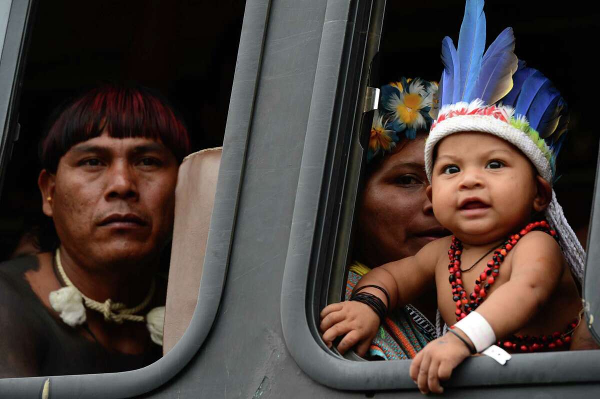 Brazilian natives watch out from the bus upon arrival at RioCentro to hand out the Kari-Oca II Declaration to leaders attending the UN Conference on Sustainable Development, Rio+20, in Rio de Janeiro, Brazil, on June 21, 2012. World leaders attending the UN summit in Rio weighed steps to root out poverty and protect the environment as thousands of activists held several protests to denounce Amazon rainforest deforestation, the plight of indigenous peoples and the "green economy" being advocated at the UN gathering. AFP PHOTO / CHRISTOPHE SIMONCHRISTOPHE SIMON/AFP/GettyImages