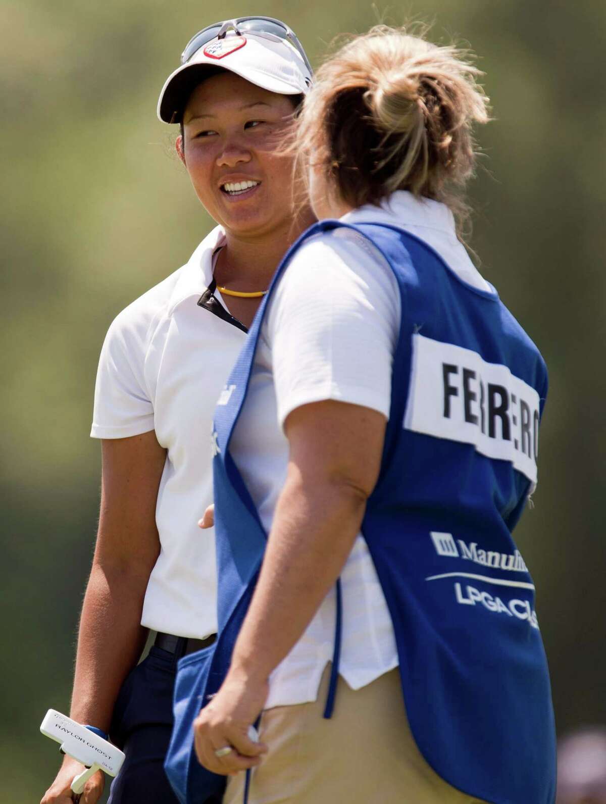 Sandra Changkija, left, smiles as she is congratulated by Lisa Ferrero's caddie after making a birdie putt from the fringe on the eighth green during the first round of the LPGA Classic golf tournament in Waterloo, Ontario on Thursday June 21, 2012.