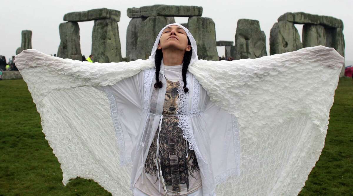 Gleu Sunpooja stands in front of Stonehenge as solstice revellers celebrate the arrival of the midsummer sunrise at the megalithic monument on June 21, 2012 near Salisbury, England. Cloudy skies and a Met Office weather warning for heavy rain meant the numbers of revellers who annually gather at the 5,000 year old stone circle to see the sunrise on the Summer Solstice was down on previous years. The solstice sunrise marks the longest day of the year in the Northern Hemisphere. (Photo by Matt Cardy/Getty Images) *** BESTPIX ***