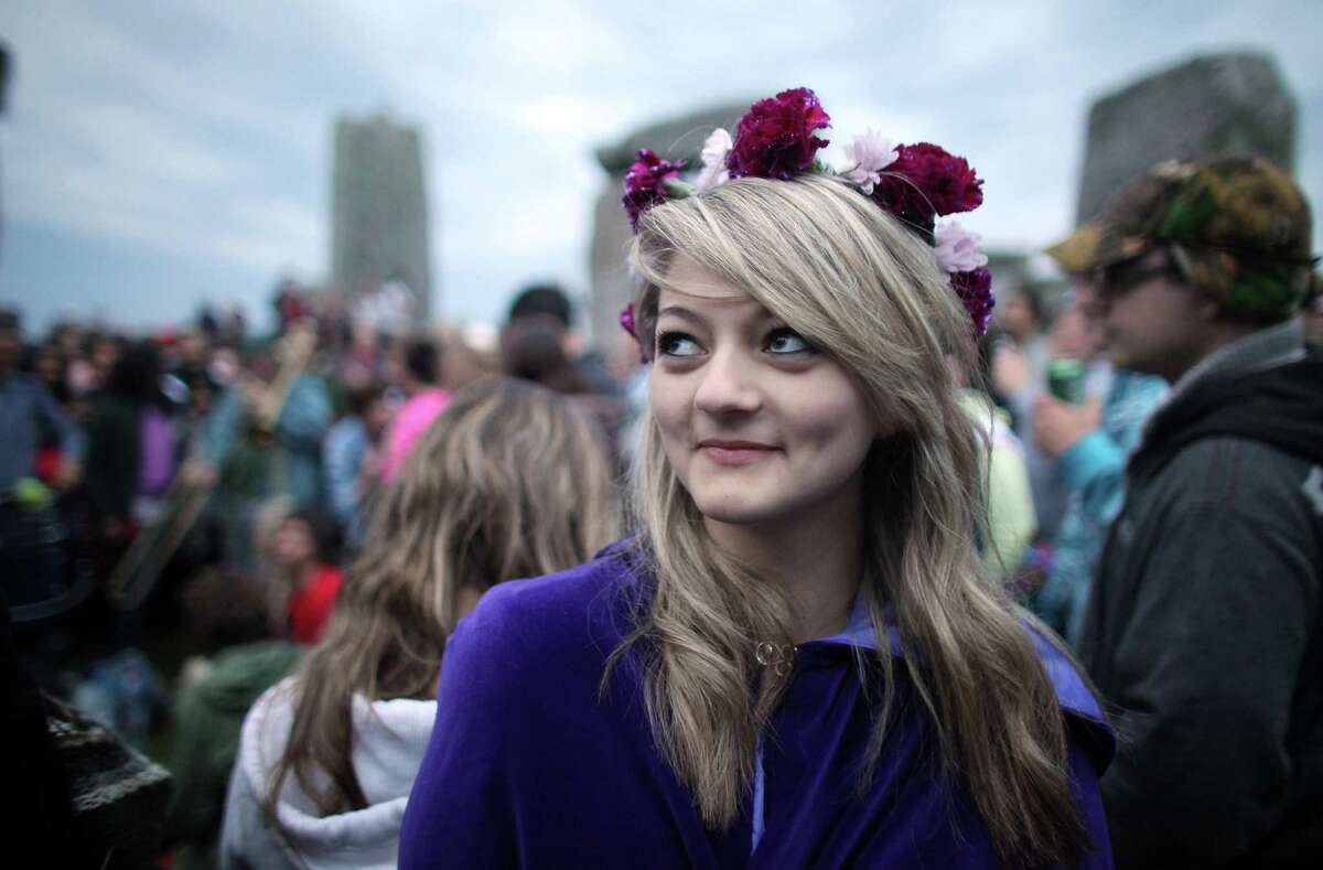 Georgina Kernnard smilles as she takes part in Solstice celebrations for the midsummer dawn at the megalithic monument of Stonehenge on June 21, 2012 near Salisbury, England. Cloudy skies and a Met Office weather warning for heavy rain meant the numbers of revellers who annually gather at the 5,000 year old stone circle to see the sunrise on the Summer Solstice was down on previous years. The solstice sunrise marks the longest day of the year in the Northern Hemisphere.