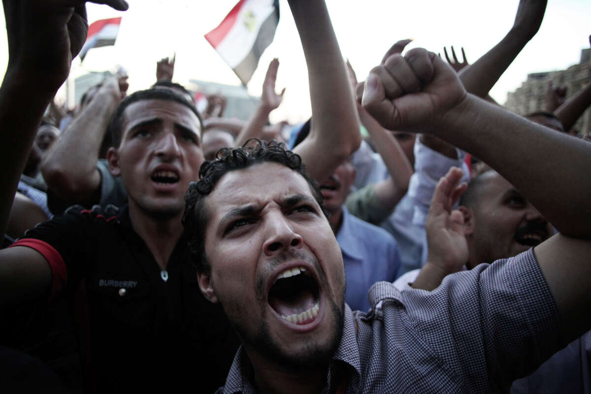 Egyptian men chant anti-Supreme Council for the Armed Forces (SCAF) slogans in Tahrir Square in Cairo, Egypt, Thursday, 21 June, 2012. Authorities delayed Thursday's planned announcement of the winner of Egypt's presidential election. Hundreds of Brotherhood supporters camped out in Cairo's Tahrir Square on Wednesday night, denouncing the ruling military and vowing to stay in place until the parliament, which was dissolved last week on a court order, is reinstated.