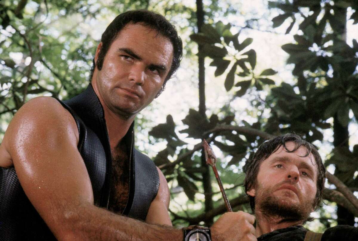 This image released by Warner Bros. Entertainment shows actor Burt Reynolds portraying Lewis Medlock, left, and Bill McKinney as Don Job in the 1972 film "Deliverance." Four decades ago, the lush northeast Georgia mountains were introduced to the world in the hit film “Deliverance.” Though many in the region still bristle at the movie’s portrayal of locals as uneducated, toothless hillbillies who sodomize visitors from the big city, the film helped create the $20 million rafting and outdoor sports industry along the Chattooga River, which splits Georgia and South Carolina and was the fictional Cahulawassee River in the movie. That’s why the communities along the Chattooga are celebrating the 40th anniversary of the movie’s release with this weekend’s first ever Chattooga River Festival. (AP Photo/Warner Bros. Entertainment)