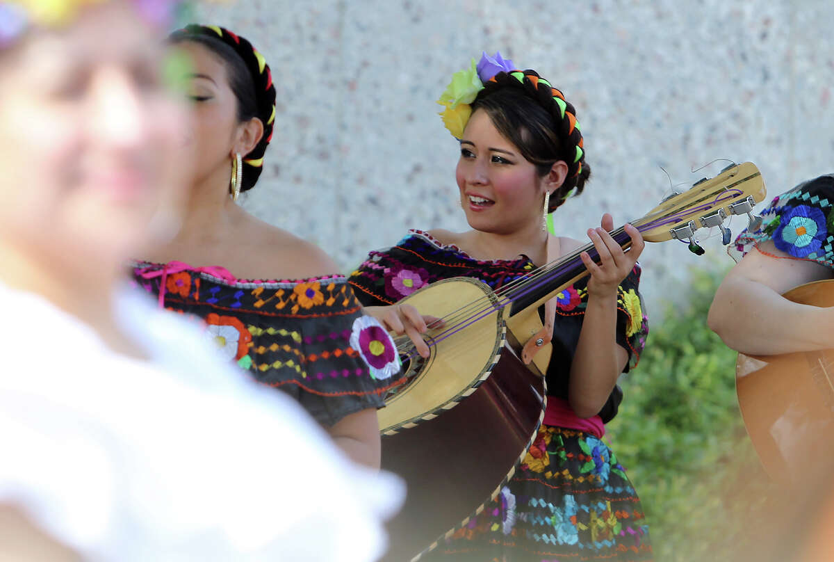 Amanda Lozano (center) plays the "guitarron" with Mariachi Flor de Jalisco as part of the day's musical entertainment as the Texas Historical Commission, Friends of Casa Navarro and the Cortez Family unveil a mural created by artist Jesse Trevino and his wife Elizabeth Rodriguez at the Casa Navarro State Historic Site on Saturday, June 23, 2012.